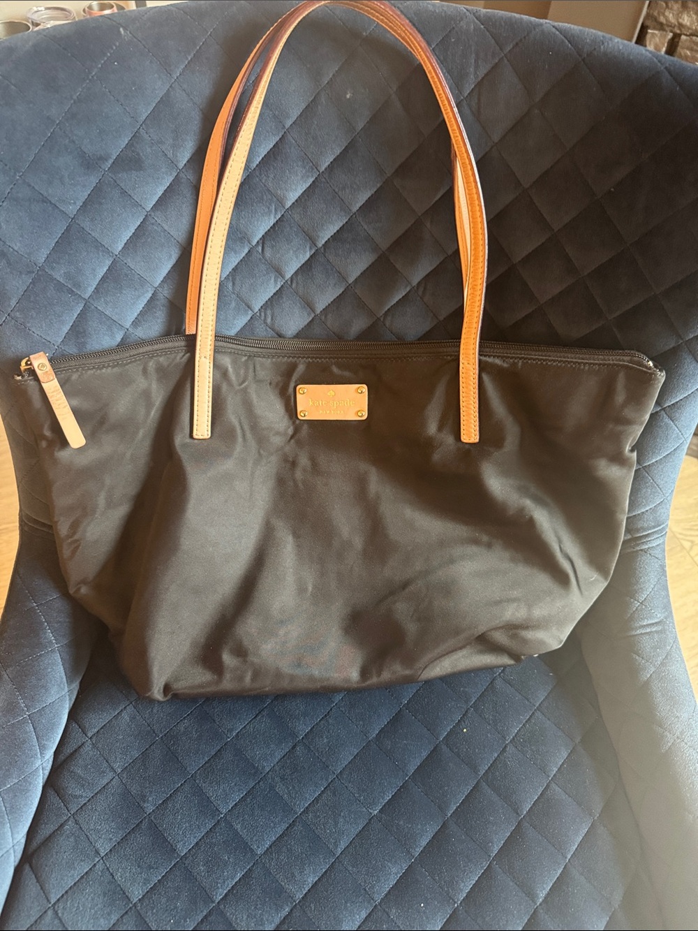 kate spade black tote with tan handles and gold logo plate